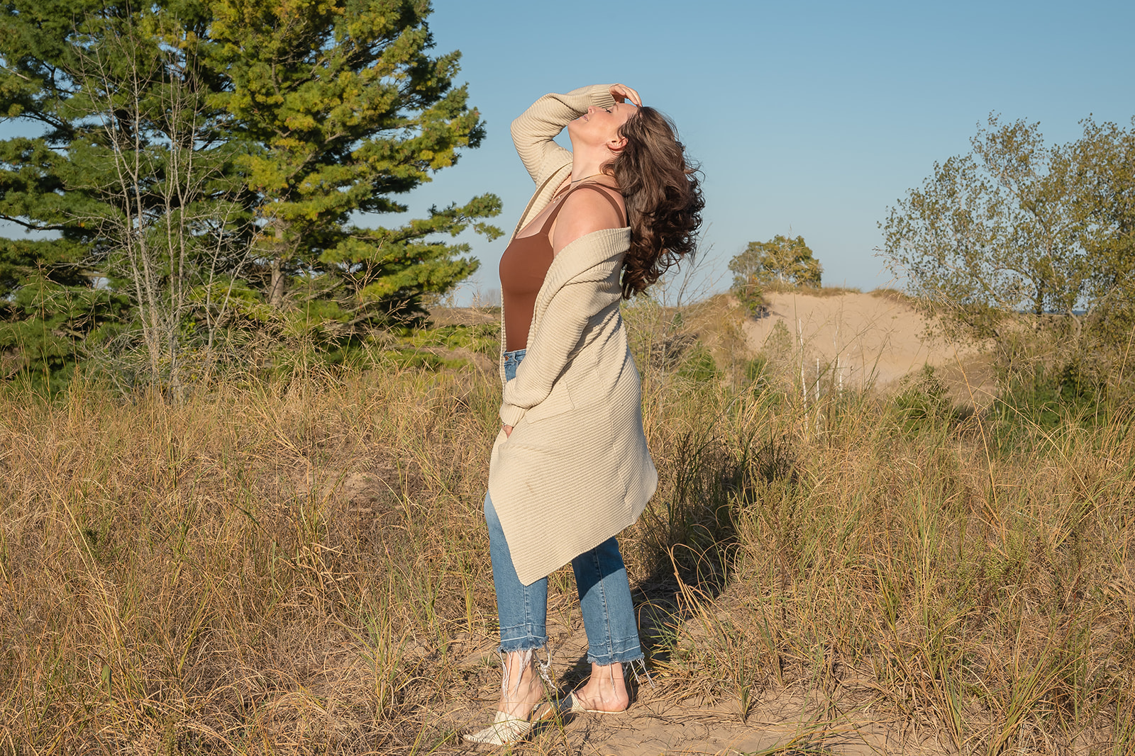 Kathryn Duklas, founder of Infinite Awareness, standing in a sand dune landscape, reflecting themes of awareness, clarity, and personal transformation